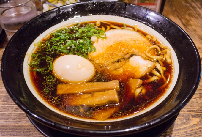 大阪ブラックと呼ばれる独特の真っ黒な醤油スープを武器に、食べログにて大阪のラーメンランキング3年連続1位に輝いたこともある名店です。大阪府内をはじめ京都や滋賀にも支店があり、その知名度は関西のラーメン屋ではトップクラスでしょう。見た目に反して味はそれほど濃くはなく、優しく主張するイカや海老が印象的。本店の営業時間は短いですが、梅田や道頓堀などの繁華街にある店舗は遅くまで営業しており、飲んだ後の〆にもオススメです。